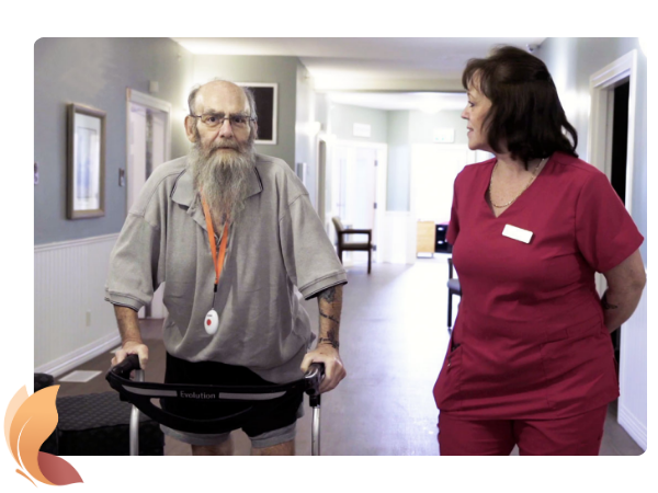 Man using his walker while strolling the halls with a staff member at Red Deer Hospice