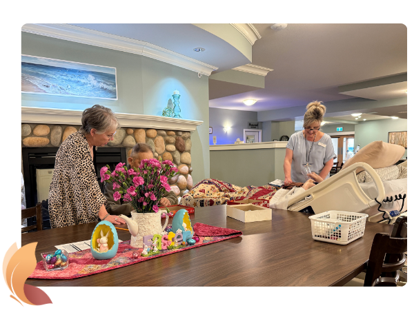 Volunteers play games and activities with residents at kitchen table in front of fireplace
